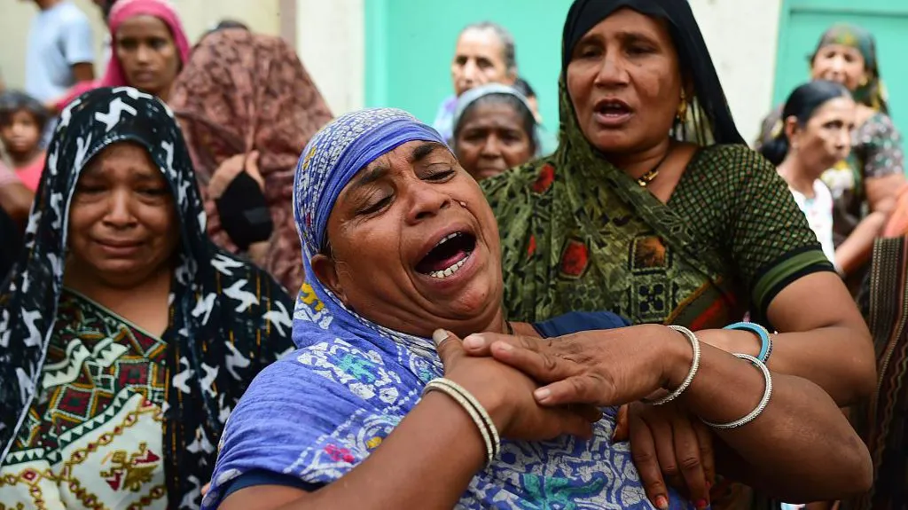 Relatives and neighbours of 14-year-old Akash Patni, one of the crash victims, mourn as they wait for his body