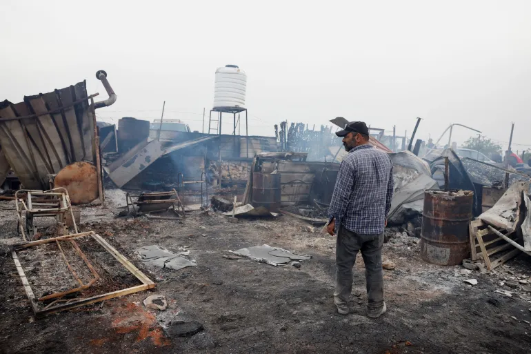 A Palestinian inspects the damage after an attack by Israeli settlers, in Sinjil, near Ramallah, in the Israeli-occupied West Bank, on April 23, 2025