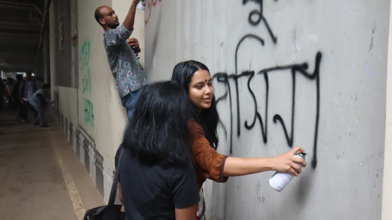 Protesters draw graffiti and write slogans against Sheikh Hasina on the walls of Dhaka