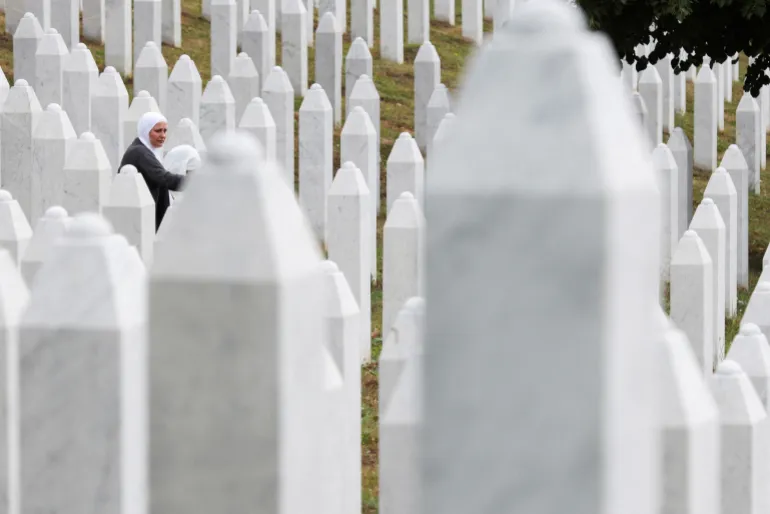 A Bosnian woman stands near the tombstone of a relative, ahead of a mass funeral marking the 30th anniversary of the Srebrenica genocide, at the Srebrenica Memorial Center in Potocari, near Srebrenica, Bosnia and Herzegovina, on July 10, 2025