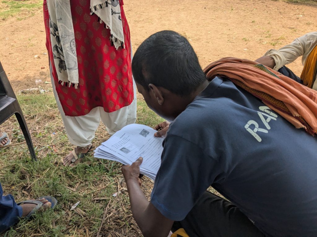 A volunteer distributes enumeration forms. Photo: Umesh Kumar Ray.