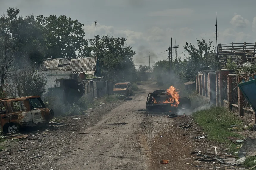 Burnt cars lie in the street as civilians are evacuated from Pokrovsk, Ukraine, by police on June 19.
