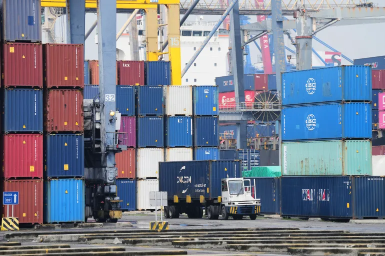 A truck drives past stacks of containers at Jakarta International Container Terminal at Tanjung Priok Port in Jakarta, Indonesia, on July 9, 2025
