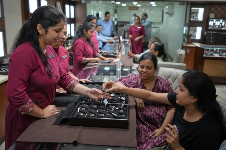A salesperson shows a diamond ring to a prospective buyer at a jewellery shop in Ahmedabad, India, on April 14, 2025