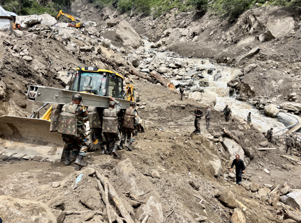 Soldiers of the Indian army carrying a steel beam to make a bridge over the Bhot tributary in Chisoti village