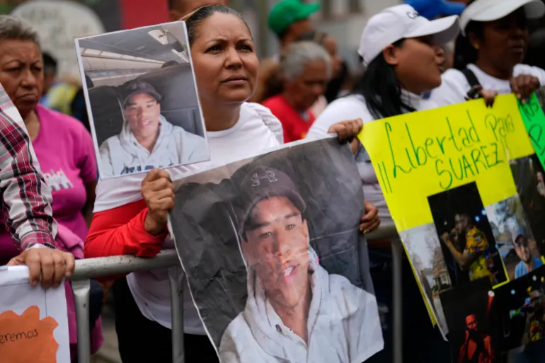 Jasmin Ramirez holds a photo of her son, Angelo Escalona, at a government-organised rally protesting against the deportation of alleged members of the Venezuelan Tren de Aragua gang, who were transferred to an El Salvador prison, in Caracas, Venezuela, on Tuesday, March 18, 2025