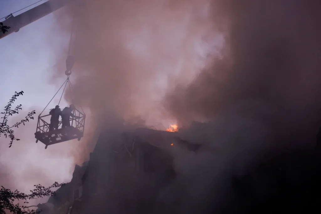 Smoke billowed from the crumbled column of a five-storey residential building in the Darnytskyi district, which suffered a direct hit. An acrid stench of burning material wafted in the air as firefighters worked to contain the blaze.