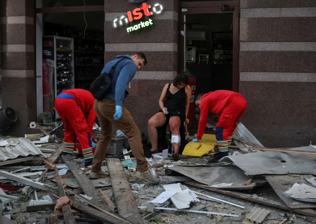 Medical workers treat a resident at the site of an apartment building hit during Russian drone and missile strikes in Kyiv.