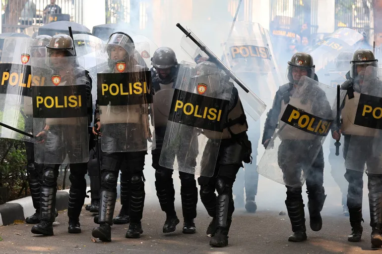Riot police react as they clash with demonstrators at the Indonesian parliament buildings in Jakarta, Indonesia, on August 25, 2025