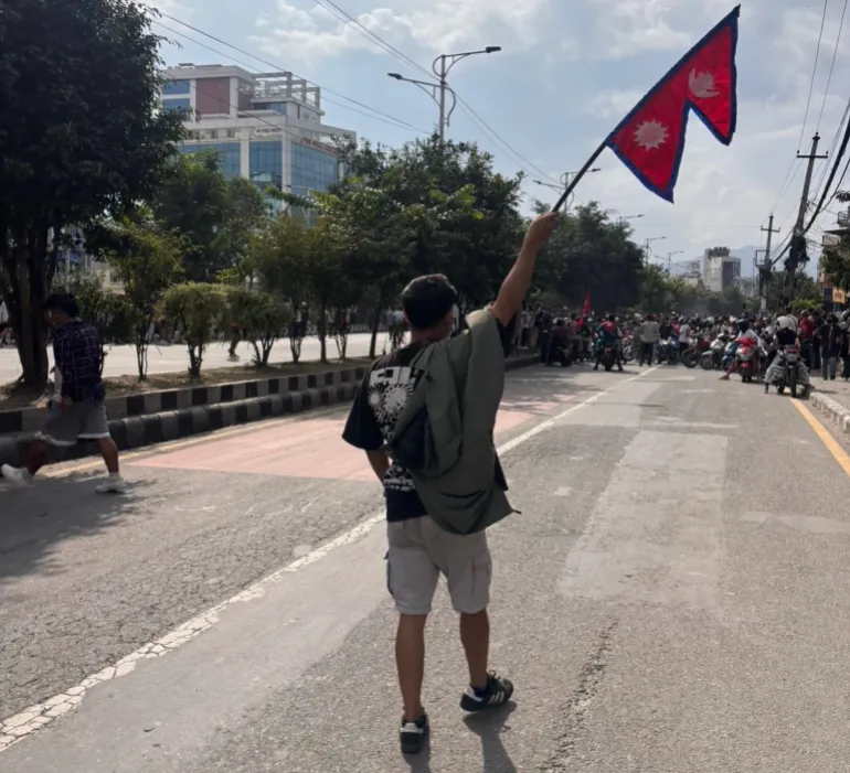 A protester marching with the national flag on a Kathmandu street