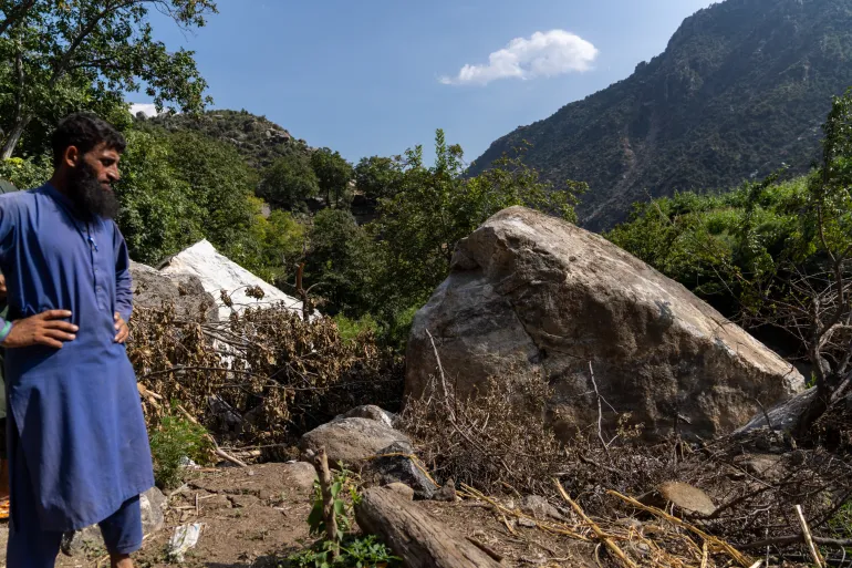 A villager looks at the boulders that destroyed Gulalai's home